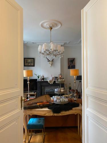 a dining room with a table and a chandelier at Amato-Brugge in Bruges