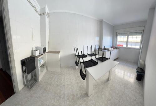 um quarto branco com uma mesa e cadeiras em Viviendas vacacionales as lagas em Palas de Rei 