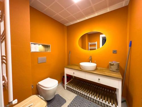 uma casa de banho laranja com um lavatório e um WC em 104- Large and Spacius em Ancara