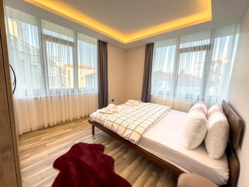 um quarto com uma cama com almofadas e janelas em 104- Large and Spacius em Ancara