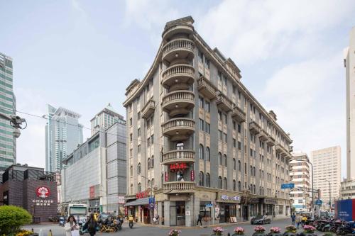 上海市にあるJingLai Bushe Hotel Bund Nanjing West Road Shanghaiの市街地に面した高層ビル(バルコニー付)