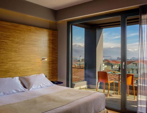 een slaapkamer met een bed en een groot raam bij Essence Hotel in Ioannina