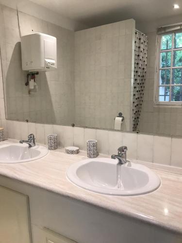 une salle de bain avec deux lavabos et un grand miroir dans l'établissement Le clos de la tour cassis piscine chauffée, à Cassis
