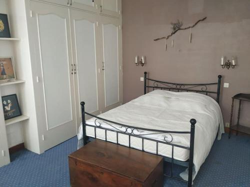 um quarto com uma cama e uma mesa de madeira em Longère charentaise familiale. em La Tremblade
