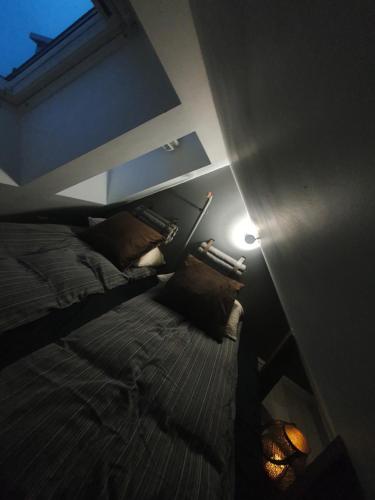 a bedroom with a bed and a light on the wall at Modern loftsleilighet in Fredrikstad