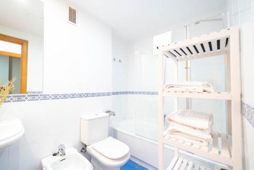 Baño blanco con aseo y lavamanos en Apartamentos GO Covaresa -Parking Gratuito, en Valladolid