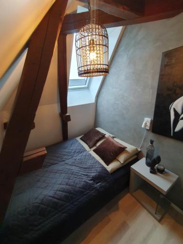 1 dormitorio con cama y lámpara de araña en Modern loftsleilighet, en Fredrikstad