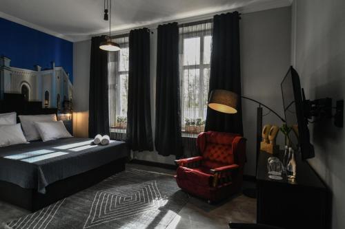 Schlafzimmer mit einem Bett, einem Stuhl und Fenstern in der Unterkunft Apartament Kopalnia przy Zamkowej w Wałbrzychu in Wałbrzych