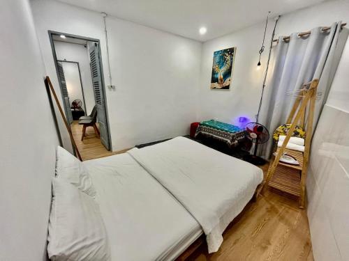 ein Schlafzimmer mit einem weißen Bett und einer Leiter in der Unterkunft Joyz House Da Lat in Da Lat