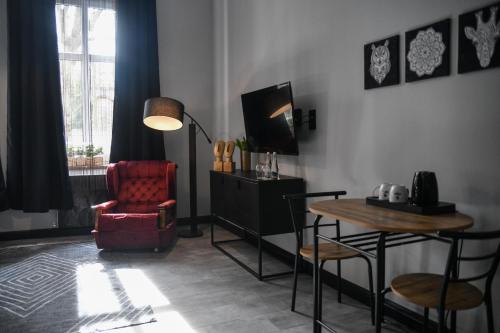ein Wohnzimmer mit einem Tisch und einem Stuhl in der Unterkunft Apartament Kopalnia przy Zamkowej w Wałbrzychu in Wałbrzych