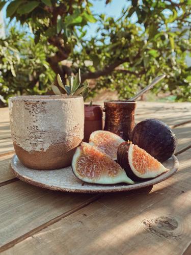 a plate with slices of fruit on a table at Quonset Glamping in Seferihisar