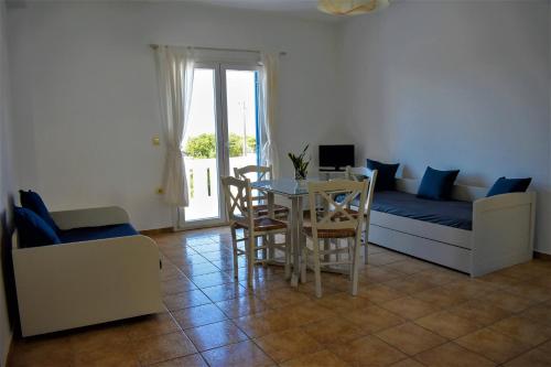 a living room with a bed and a table and chairs at Villa Maniati Studios in ayios Petros