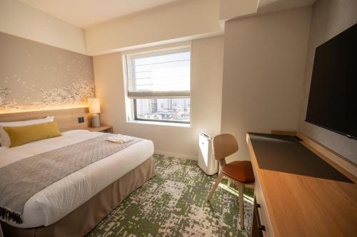 Cette chambre comprend un lit et une télévision à écran plat. dans l'établissement Hotel Terrace the Garden Mito, à Mito
