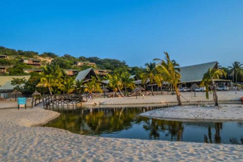 a beach with palm trees and a body of water at Katembe Beach Paradise in Maputo