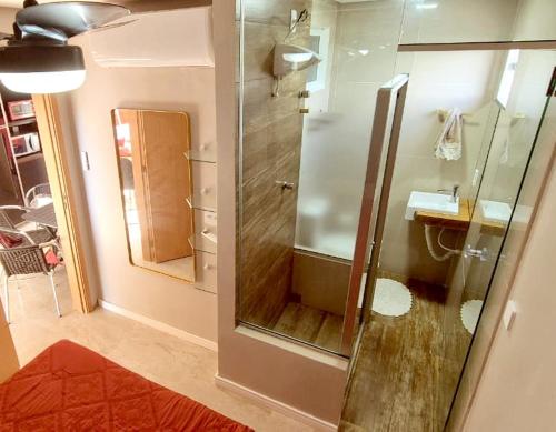 a bathroom with a shower with a sink and a mirror at Salt Beach Residence Inn in Salinópolis