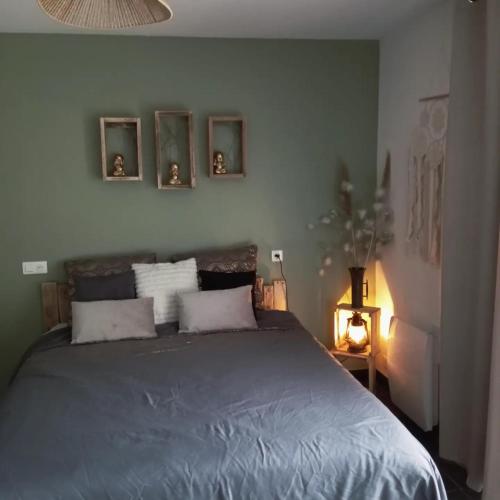 a bedroom with a bed with three pictures on the wall at La guitoune in Laroque