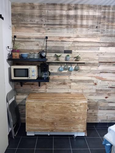 a wooden wall with a microwave in a room at La guitoune in Laroque