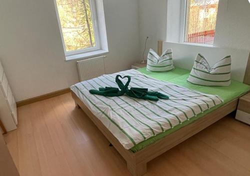 ein Bett mit einem Paar Schuhe drauf in der Unterkunft Ochelschmiede in Rathmannsdorf