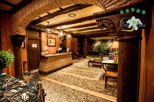 a large lobby with a large room with a stone floor at Hotel Rural Peña Del Alba in Arroyomolinos de la Vera