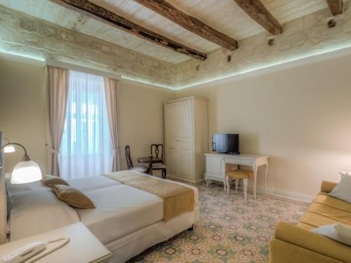 a bedroom with a bed and a desk and a couch at Tano's Boutique Guesthouse in Valletta