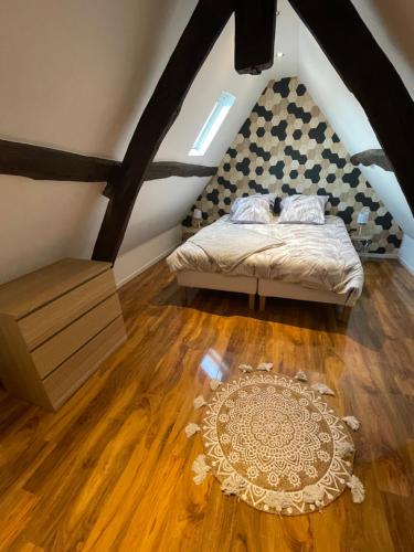- une chambre avec un lit et un tapis sur du parquet dans l'établissement Bmco cottage, à Estrées-Saint-Denis