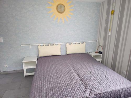 Un dormitorio con una cama morada con un sol en la pared en Ferienappartement Marx, en Lütz