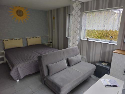 1 dormitorio con cama, sofá y ventana en Ferienappartement Marx, en Lütz