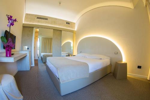 a hotel room with a large bed and a mirror at Dealuna Motel in Fidenza