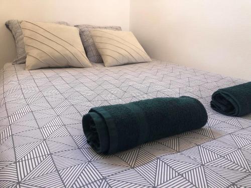 a bed with a green rolled up towel on it at Le Buc - Gare Versailles Chantiers - Netflix in Versailles