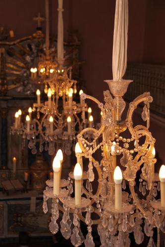 a chandelier with white candles in a room at Schloss Auel Boutique Hotel & Design Golf Lodge in Lohmar