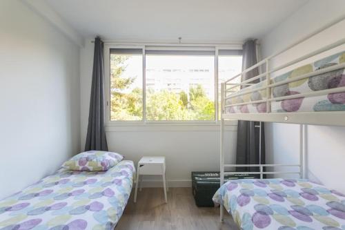 - une chambre avec des lits superposés à côté d'une fenêtre dans l'établissement Joli Duplex rénové à neuf de 72m², à Fresnes