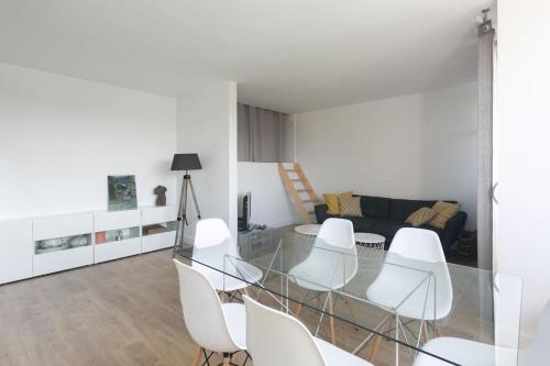 - un salon avec une table en verre et des chaises blanches dans l'établissement Joli Duplex rénové à neuf de 72m², à Fresnes