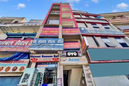 a tall building with colorful signs on it at OYO Flagship Residence Inn Guest House in Patna
