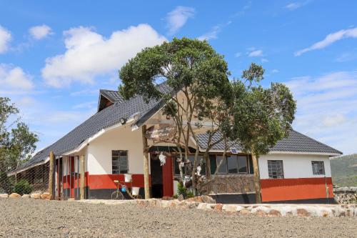 a house with a tree in front of it at Orng'atuny Mara King Camp in Masai Mara
