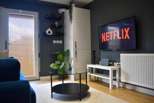 a living room with a table and a tv at Stylish Peckham Apartment 10 Seconds From Station in London