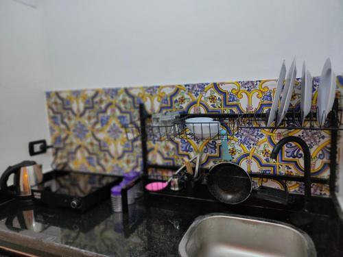 a kitchen counter with a sink and knives on a wall at Las Vegas House Dahab in Dahab