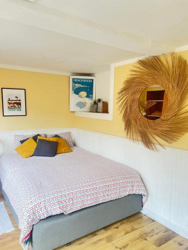 Schlafzimmer mit einem Bett und einem Wandspiegel in der Unterkunft Maisonnette avec escalier in Menton