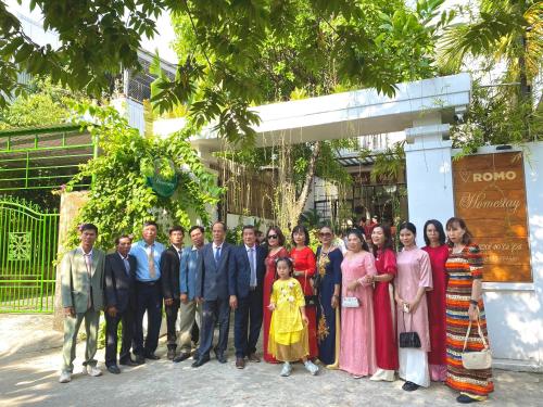 a group of people posing for a picture in front of a building at Romo Homestay in Quang Ngai