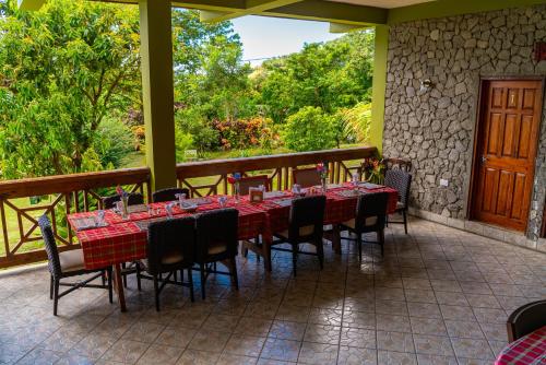 a restaurant with tables and chairs on a patio at Roxy's Mountain Lodge in Roseau