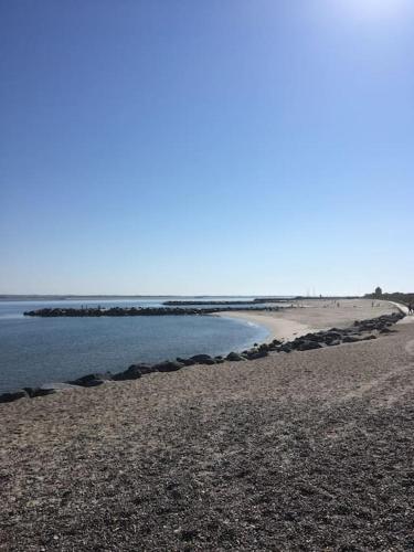 a beach with a rocky shore and the ocean at Nyd den skønne natur ved hav og fjord in Thyborøn