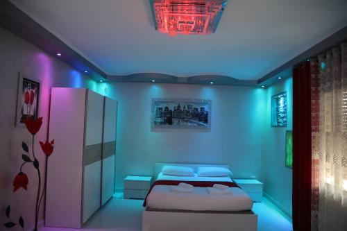um quarto com uma cama com iluminação roxa em CASA GENA em Veneza
