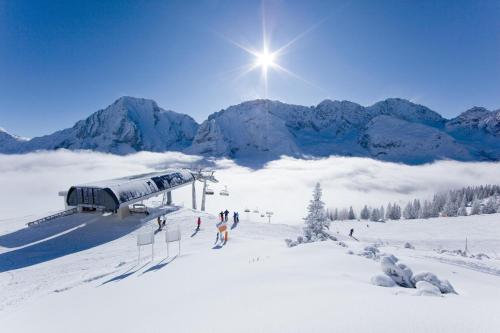a group of people on a ski lift in the snow at Chalet Melodie in Ehrwald