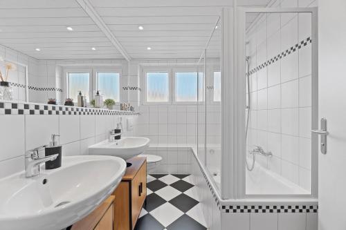 - une salle de bains blanche avec deux lavabos et une douche dans l'établissement LUMIFLATS: Mahlberg, à Mahlberg