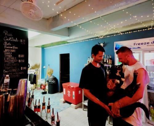 two men are holding a woman in a wine store at Tiki Tribe Bar & Hostel in Koh Tao