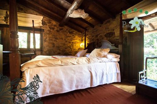 a bedroom with a bed in a stone wall at Hotel Rural Peña Del Alba in Arroyomolinos de la Vera