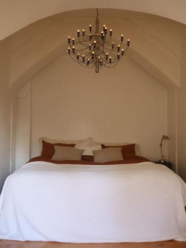 a bedroom with a large white bed with a chandelier at Spacious Penthouse close to center in Stockholm