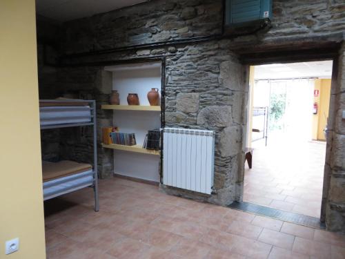 een kamer met een stapelbed en een stenen muur bij Obradoiro in Sarria