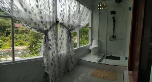 New The Heritage Resort & Restaurant Bukit Lawang في Bandartelu: حمام مع دش ومرحاض ونافذة