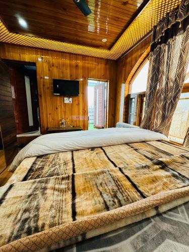 uma cama grande num quarto com paredes de madeira em Frosty Mountain Resort em Pahalgam