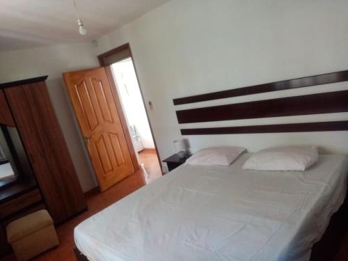 a bedroom with a large bed and a wooden door at Tonishka Villa in Trou aux Biches